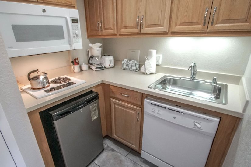 Photo of Kitchen with dishwasher, mini refrigerator, microwave, stove, sink and cabinets