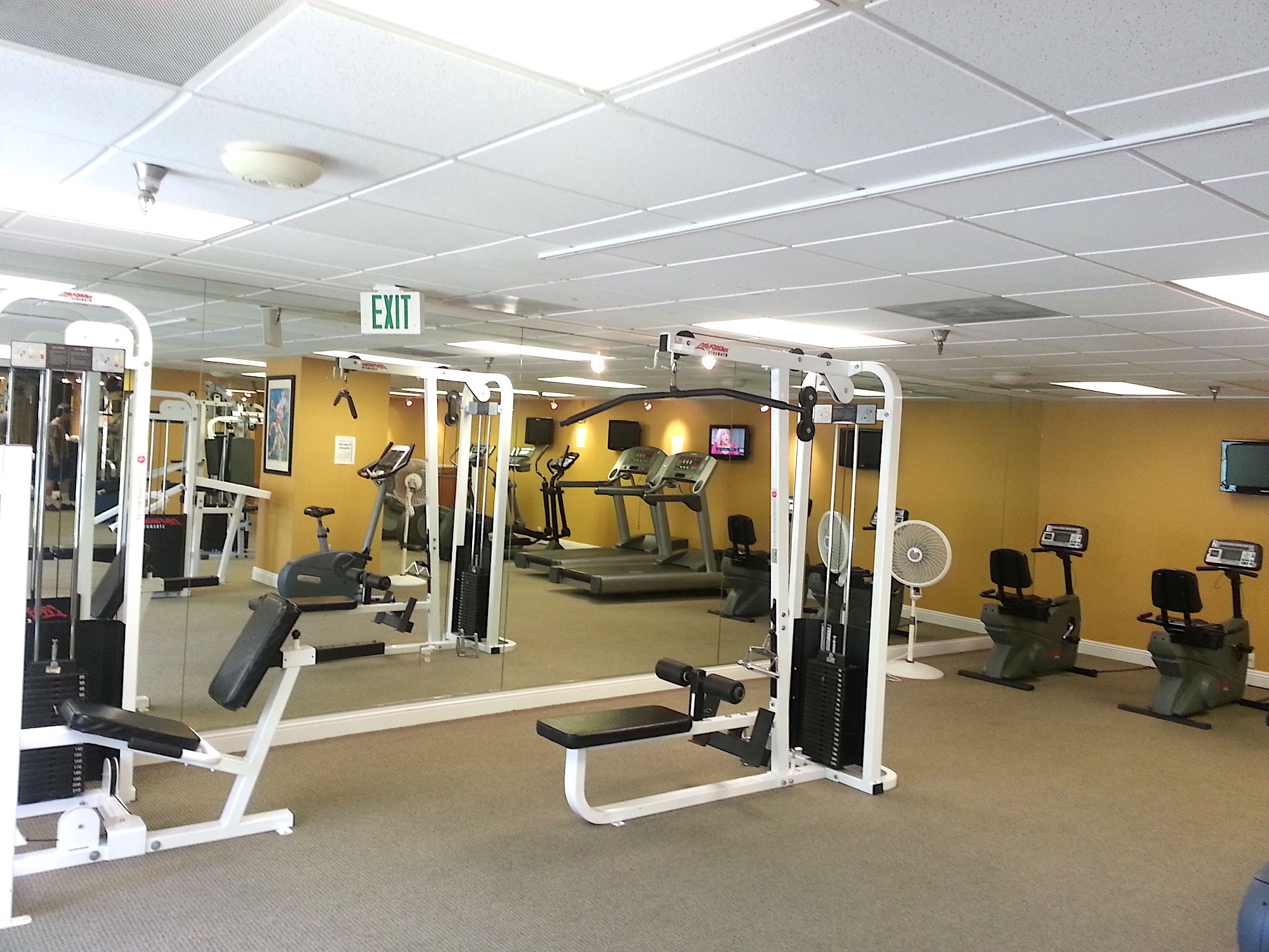 A fitness center with exercise equipment, including treadmills, stationary bikes, and weight machines.