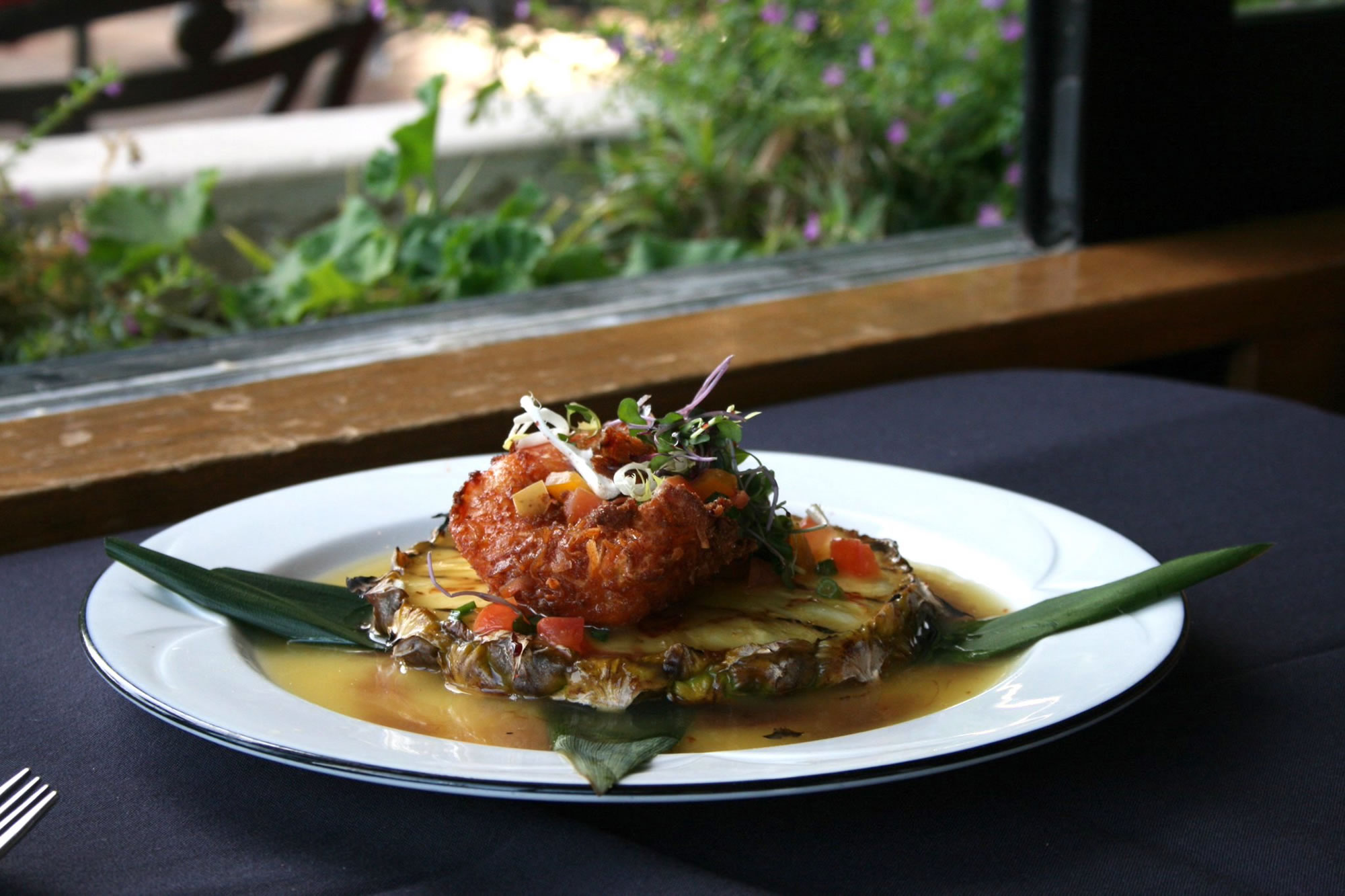 A plate of food on a table in front of a window.